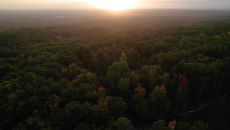 antena de un amanecer sobre los árboles de follaje de otoño en las montañas de new hampshire en el otoño