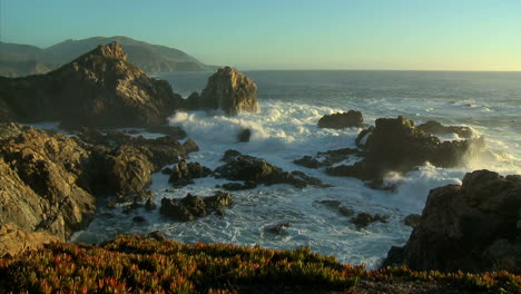 waves and surf from a winter storm pound the big sur coastline of california