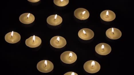 velas - pequeñas velas ardiendo sobre fondo negro