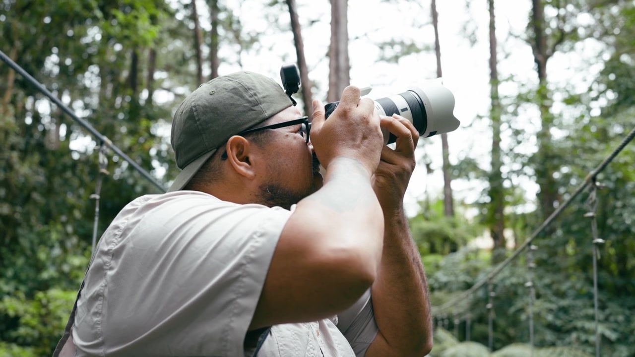 Photographer Taking Pictures on a Suspension Bridge in the Forest