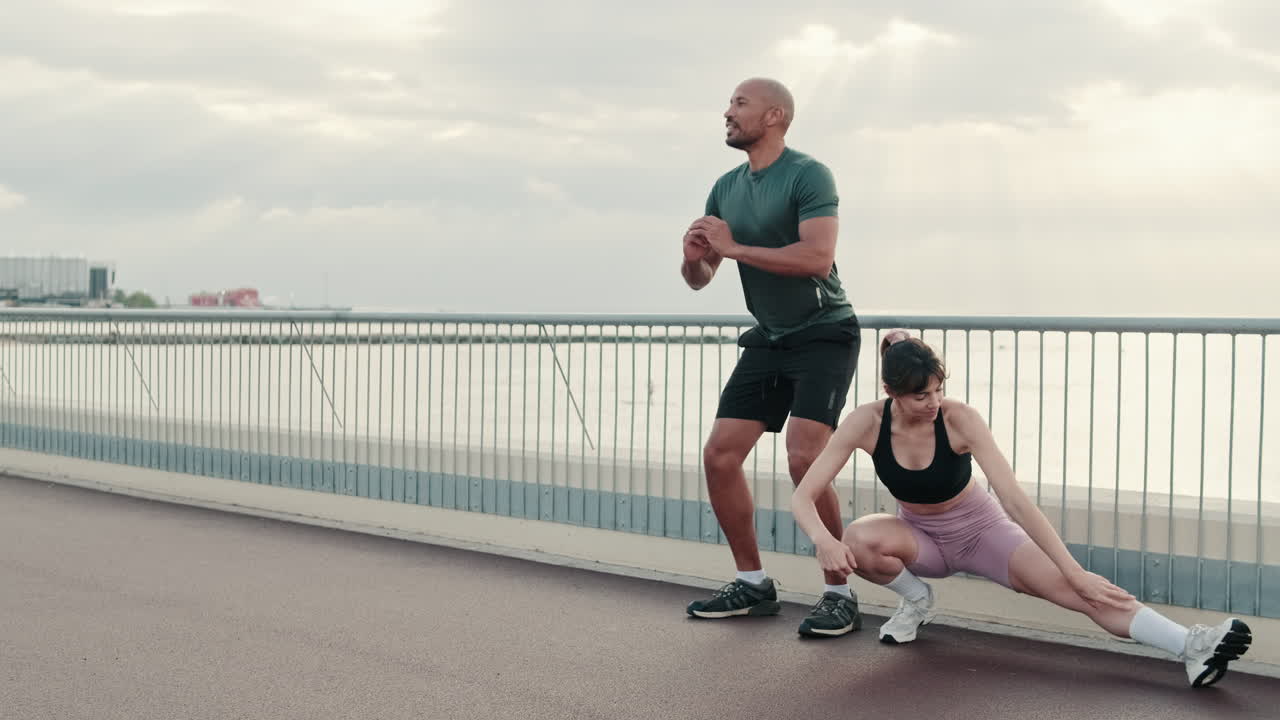 Athletic Couple Stretching Before an Outdoor Workout