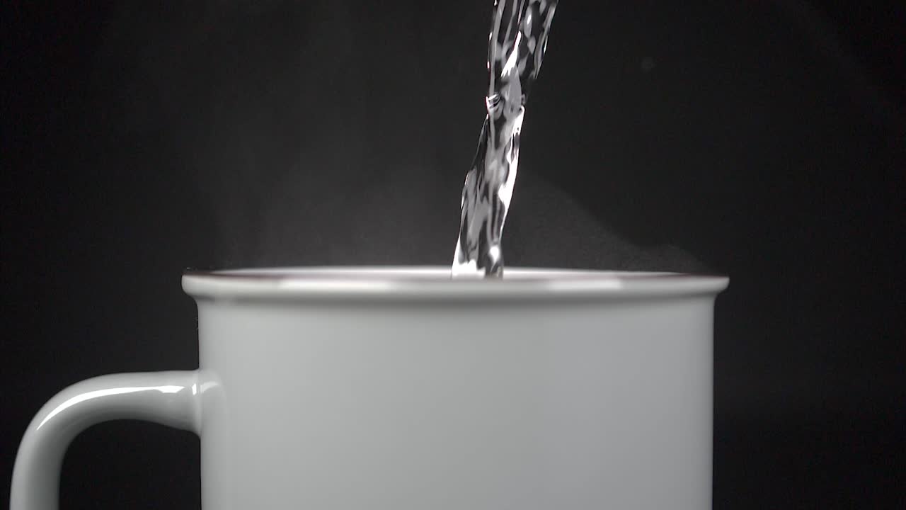 Tazza che si riempie di acqua calda con vapore, slow motion 4K