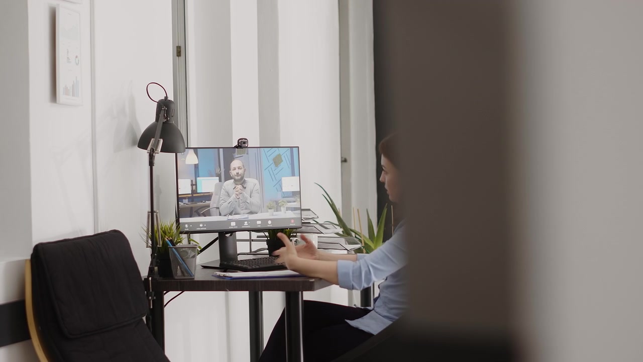 Kvinne har en videosamtale med en mann på hjemmekontoret sitt