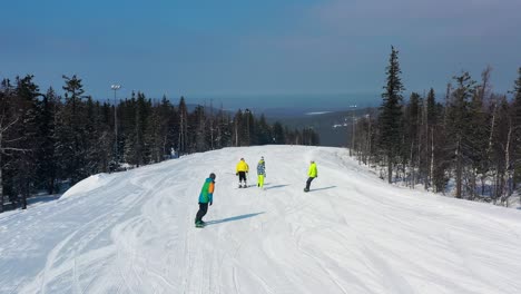 esquiadores y snowboarders en una ladera de montaña nevada