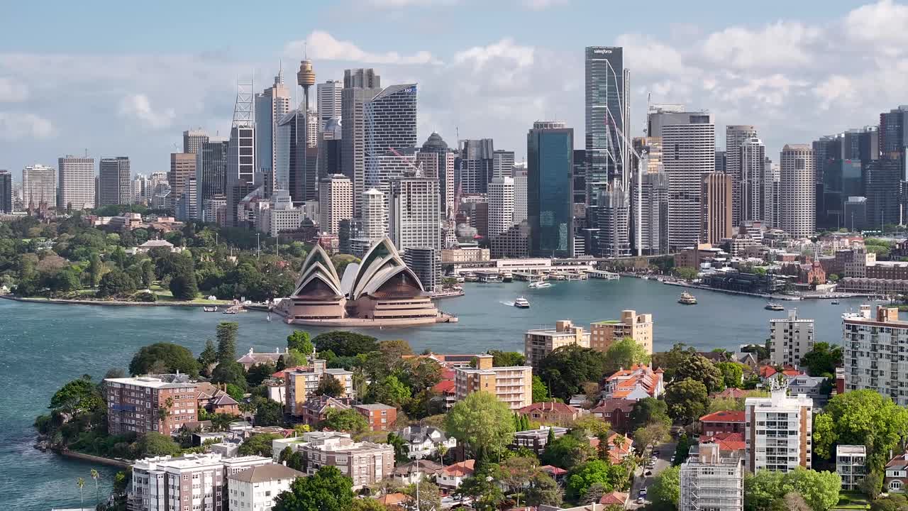 Sydney beautiful drone pull back cityscape over residential area to downtown skyscrapers and Opera House.