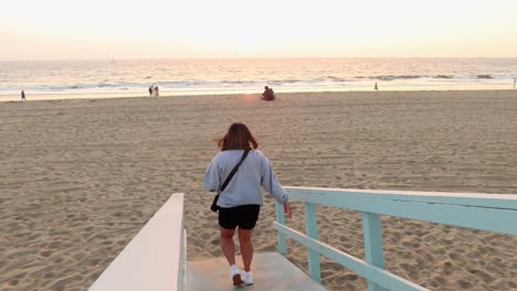 video de viaje de una chica caminando en la playa durante la hora dorada