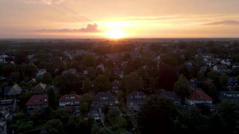 low aerial of houses in a suburban neighborhood at sunrise - drone flying backwards