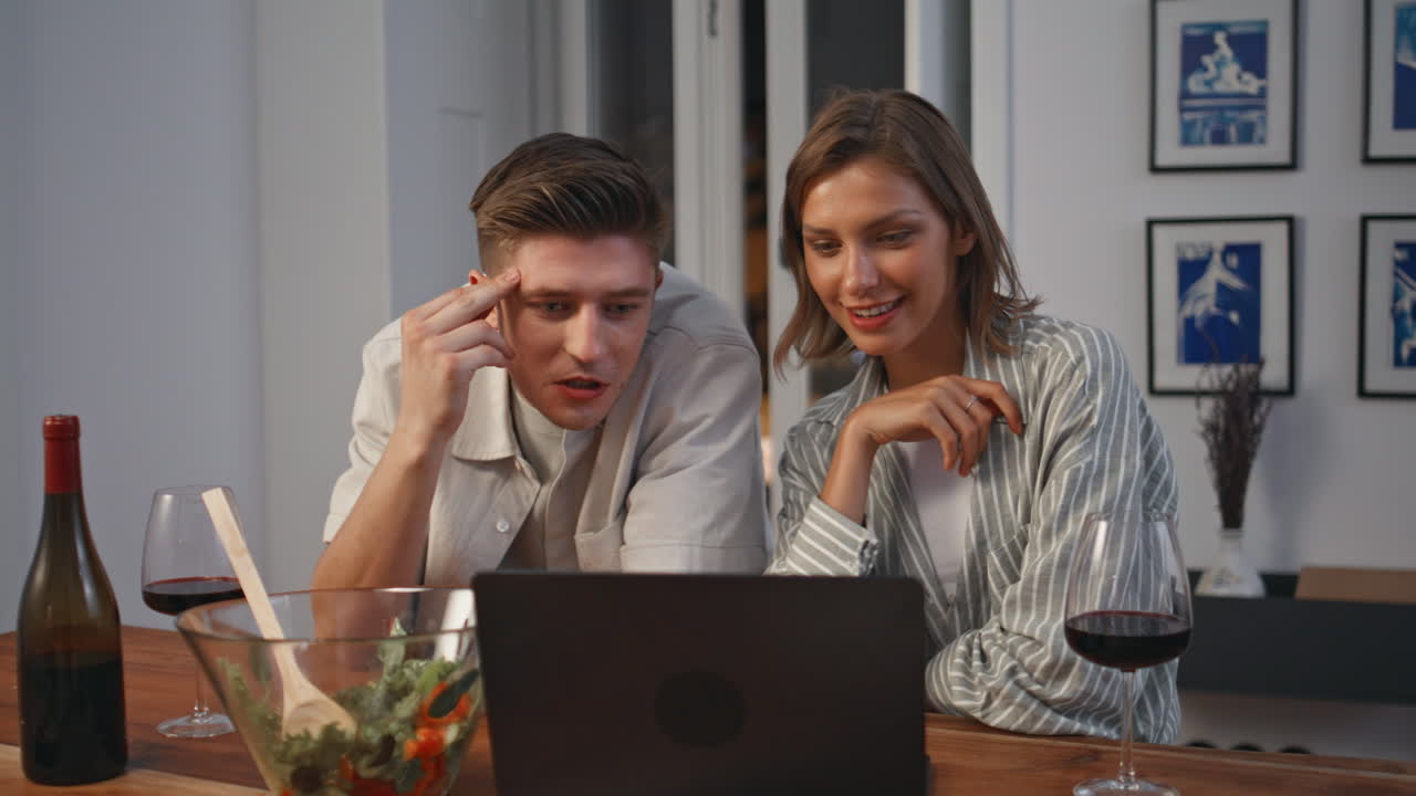 Happy pair discussing movie in evening closeup. Excited couple watching laptop