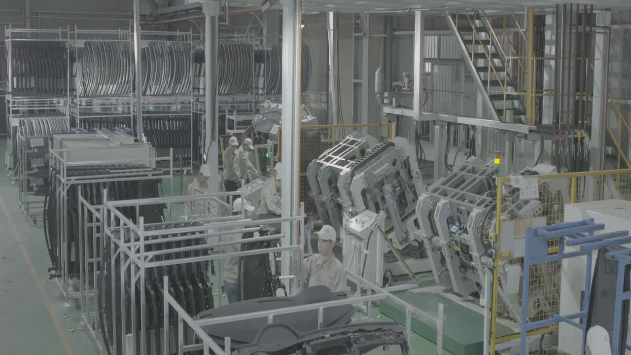 Technician specialist last checking examining auto part after and before stamping metal machine semi feeding steel sheet for car parts. Well-lit automotive factory inspecting and assembling vehicles