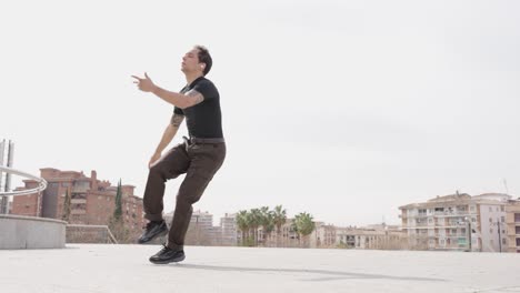 energetic male dancer performing modern choreography outdoors