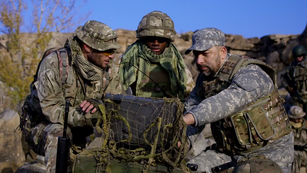 soldado afroamericano armado mirando una computadora