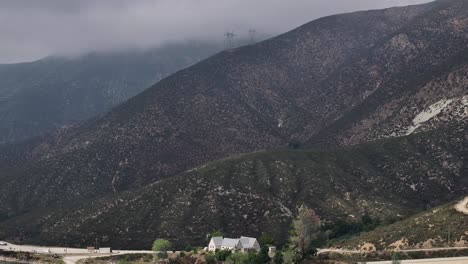 small-house-on-bouquet-reservoir-on-a-moody-dreary-day-AERIAL-TELEPHOTO-DOLLY-BACK-TILT-UP-60fps