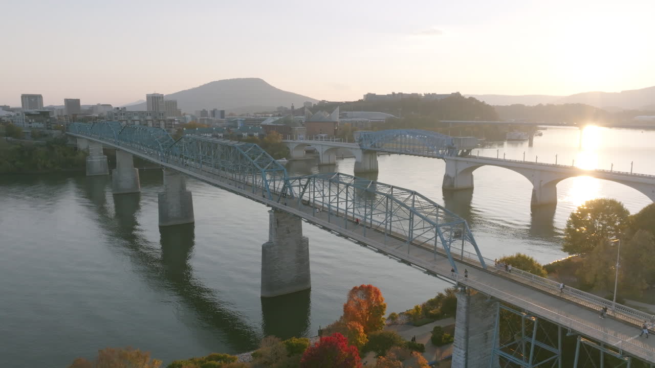 테네시 주 채터누가에서 일몰 동안 사람들이 걷는 동안 호두 거리 다리 주위를 회전하는 항공 영상