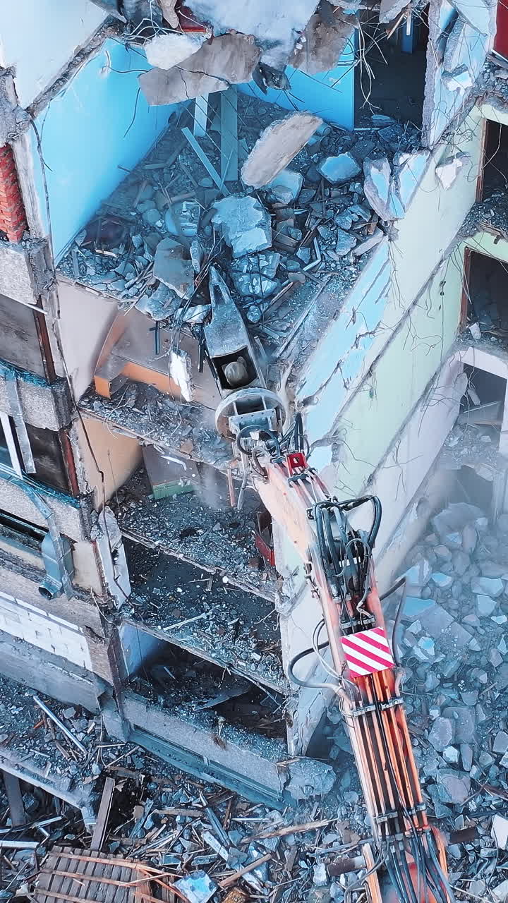 Aerial view of destruction by machine. Excavator demolition constructions.