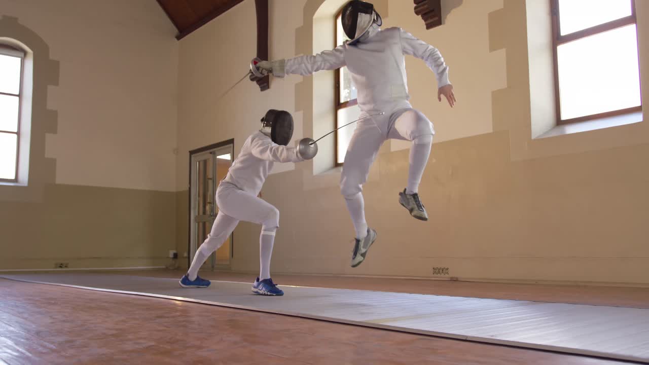 atletas de esgrima durante un entrenamiento de esgrima en un gimnasio