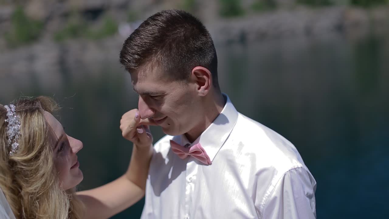Groom And Bride Hugging Outdoor. Groom and bride on river bank at romantic moment