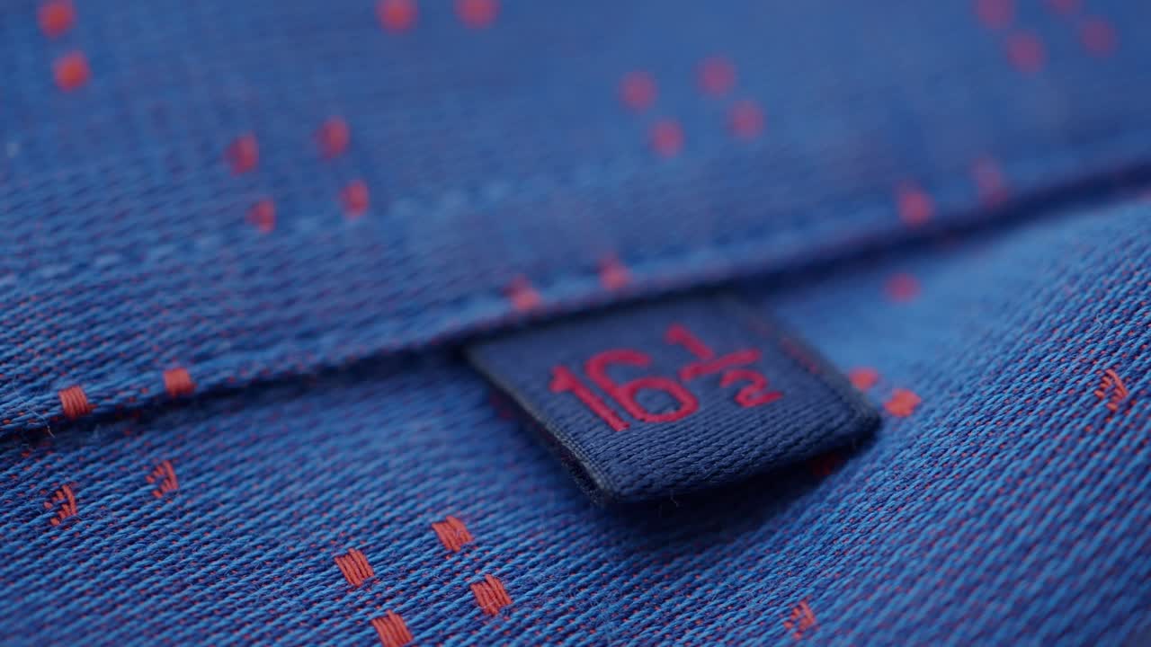 "16 1 2"라는 크기 태그를 가진 파란색 드레스 셔츠의 클로즈업