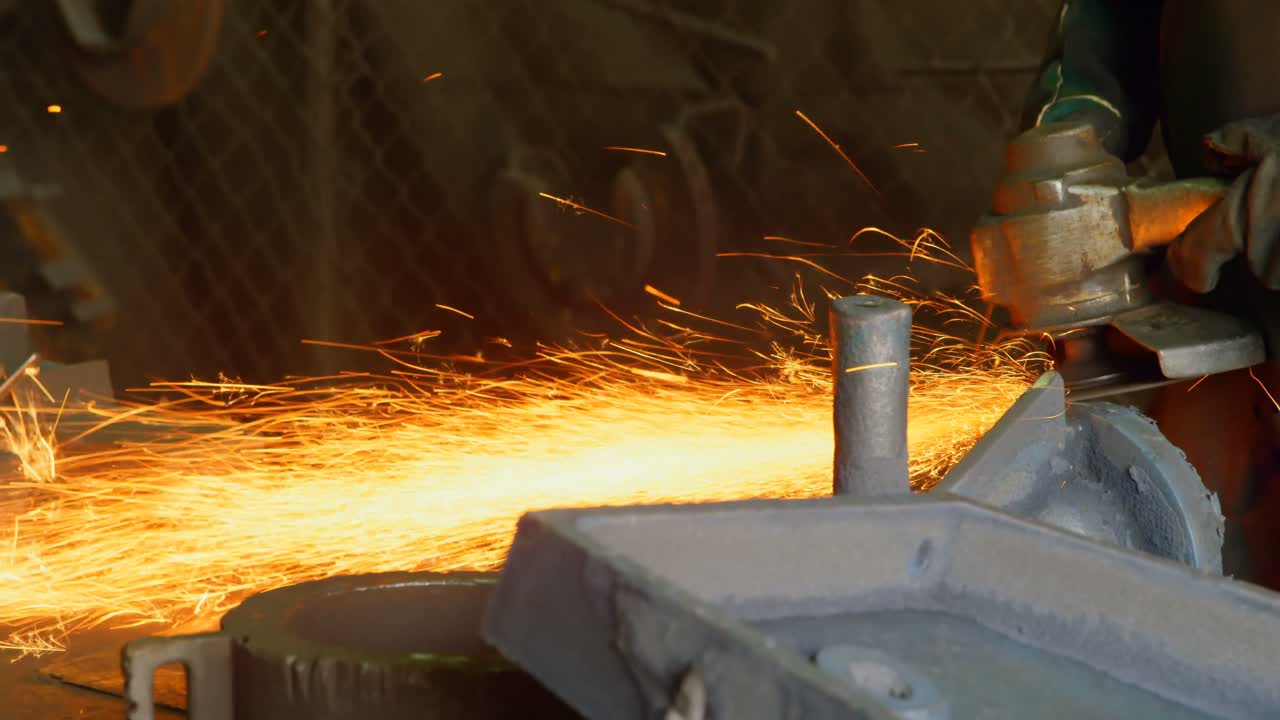 Worker using hand grinder machine in foundry workshop 4k