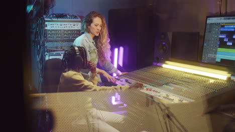 african american man and caucasian woman talking in recording studio