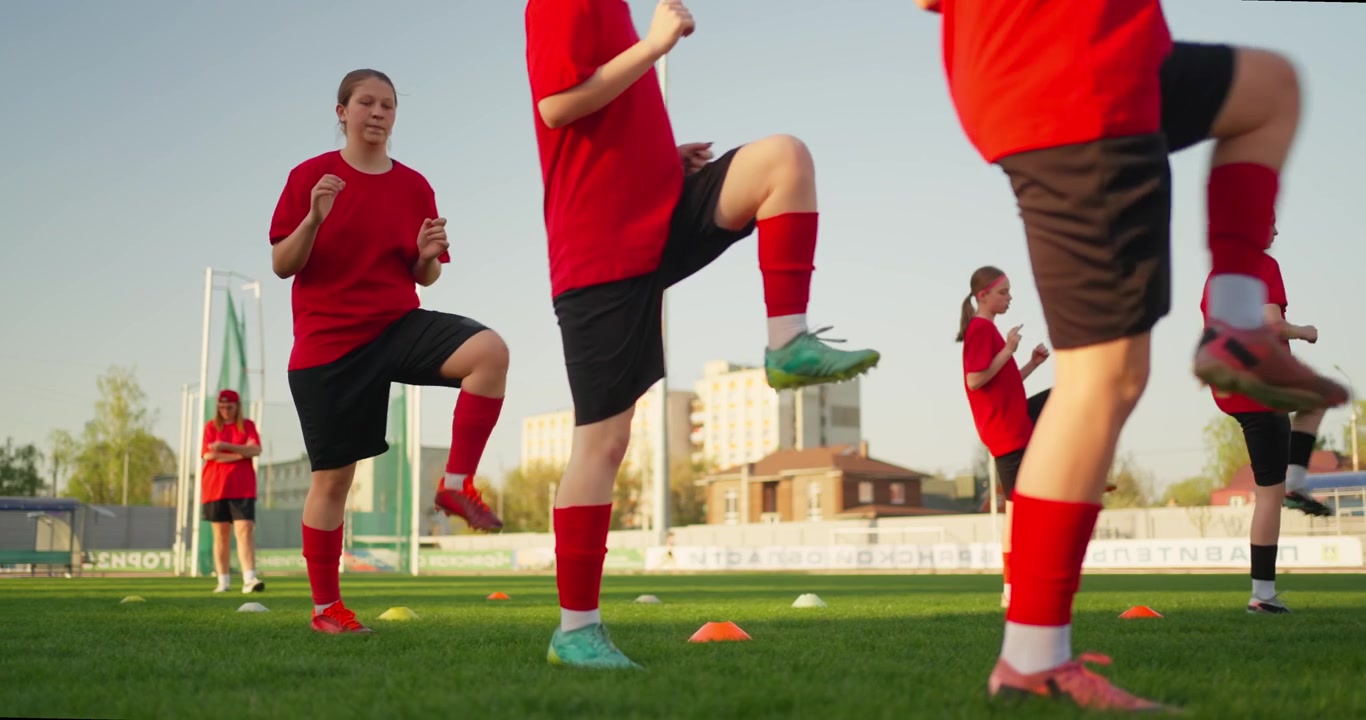 Giovani calciatrici che fanno esercizi di riscaldamento sul campo