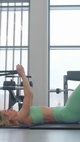 woman doing core workout with resistance bands in a gym