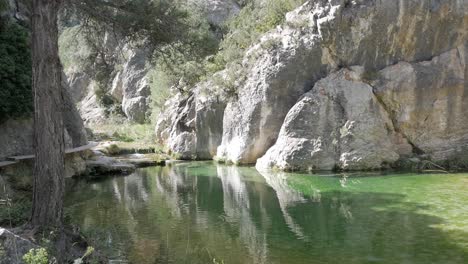 tranquil green pool under rocky cliffs in parrizal de beceite, teruel, spain