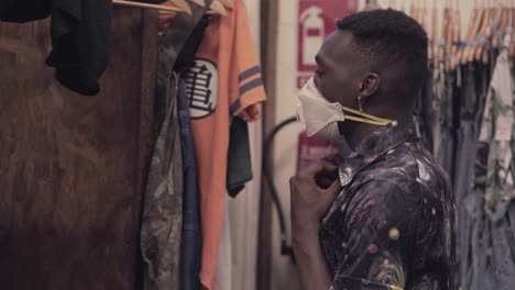 man wearing mask in clothing store