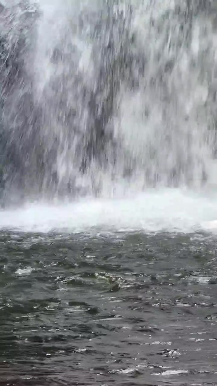 Acqua che scende da una cascata rocciosa in un ruscello