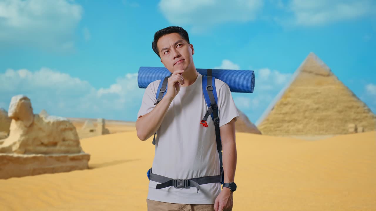 Asian Male Hiker With Mountaineering Backpack Thinking About Something And Looking Around Then Raising His Index Finger While Traveling In Pyramid Of Giza
