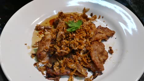 Gebratenes-Schweinefleisch-Mit-Knoblauch-Und-Pfeffer-Dekorieren,-Thailändisches-Gericht-Mit-Korianderblatt,-Nahaufnahme,-Zeitlupe