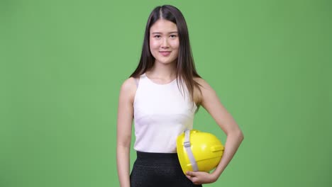 young beautiful asian businesswoman as engineer giving thumbs up