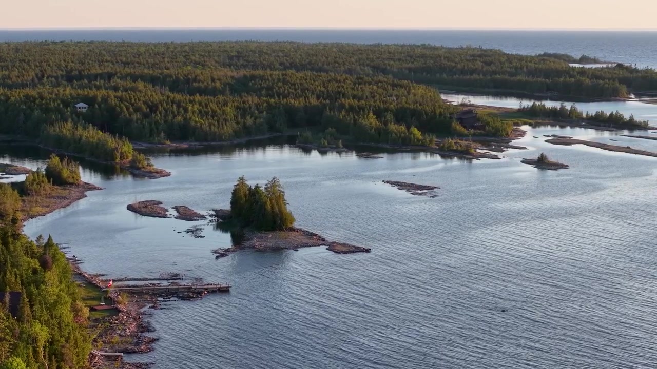 Drone liitää leveän Huronjärven vesien yllä, joita täplittävät matalat kallioiset saaret Tobermoryn metsän vieressä