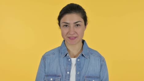 젊은 인디언 여성이 지시하고 초대, 노란색 배경