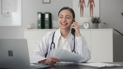 Happy-Indian-female-doctor-explaining-medical-report-to-patient-on-call