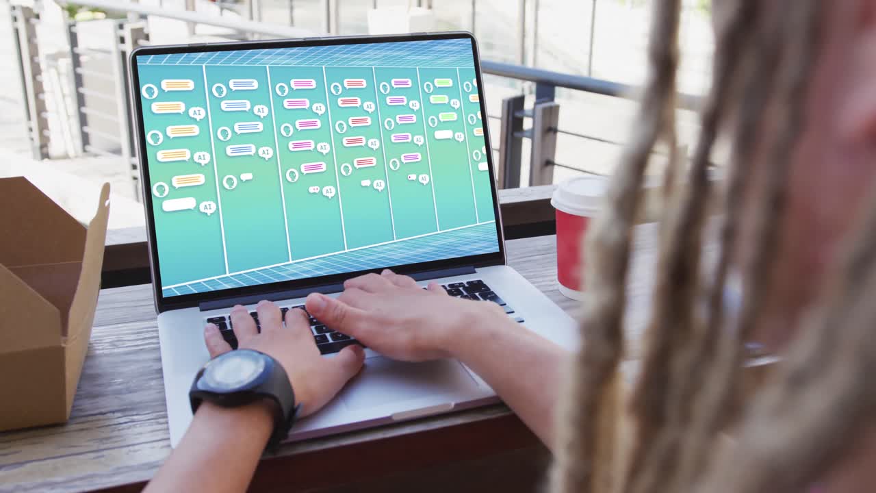 un hombre de negocios biracial usando una computadora portátil con notificaciones de mensajes en la pantalla de la oficina.