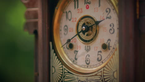 antique wooden pendulum clock in a forest close up shot slow motion