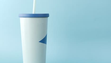 white tumbler with blue design and straw