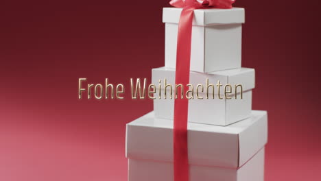 Frohe-Weihnachten-Text-Over-White-Christmas-Gifts-On-Red-Background