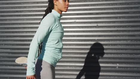 African-american-woman-in-sportswear-stretching-in-street-before-exercising