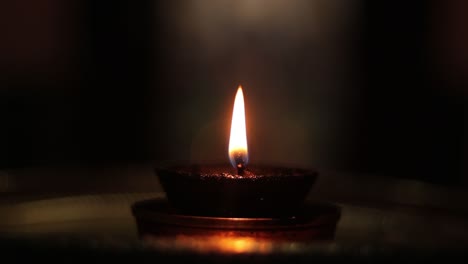 concepto de luz en la oscuridad que se muestra con diwali terracota diya o lámpara de luz en una habitación oscura