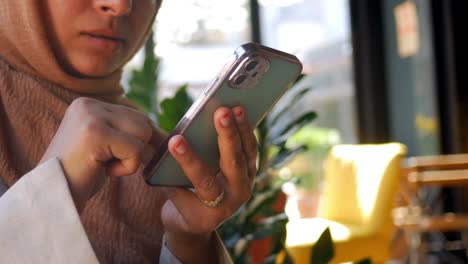 mujer usando un teléfono inteligente en un café