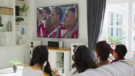composite of happy family sitting at home together watching sports event on tv