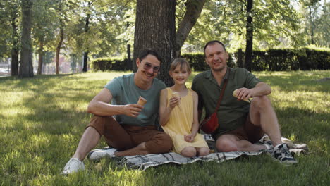 gay couple with daughter in park