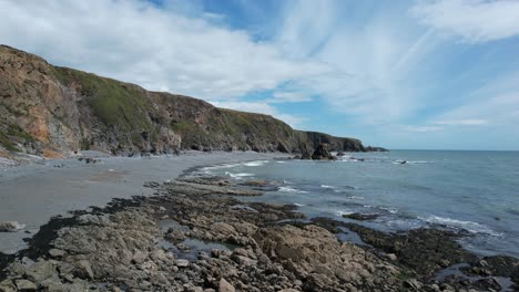 Drone-flight-along-the-beach-at-Tankardstown-Beach-Copper-Coast-Waterford-Ireland-seastacks-and-seagulls-on-a-summer-day