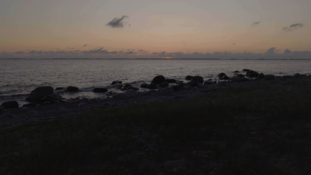 Alaviisto dronekuva kivisestä rannasta ja tyynestä merestä, tunnelmallinen auringonlasku Örössä, Suomessa