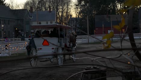 un carruaje de caballos pasa por santa mientras se agita en una ciudad anticuada.