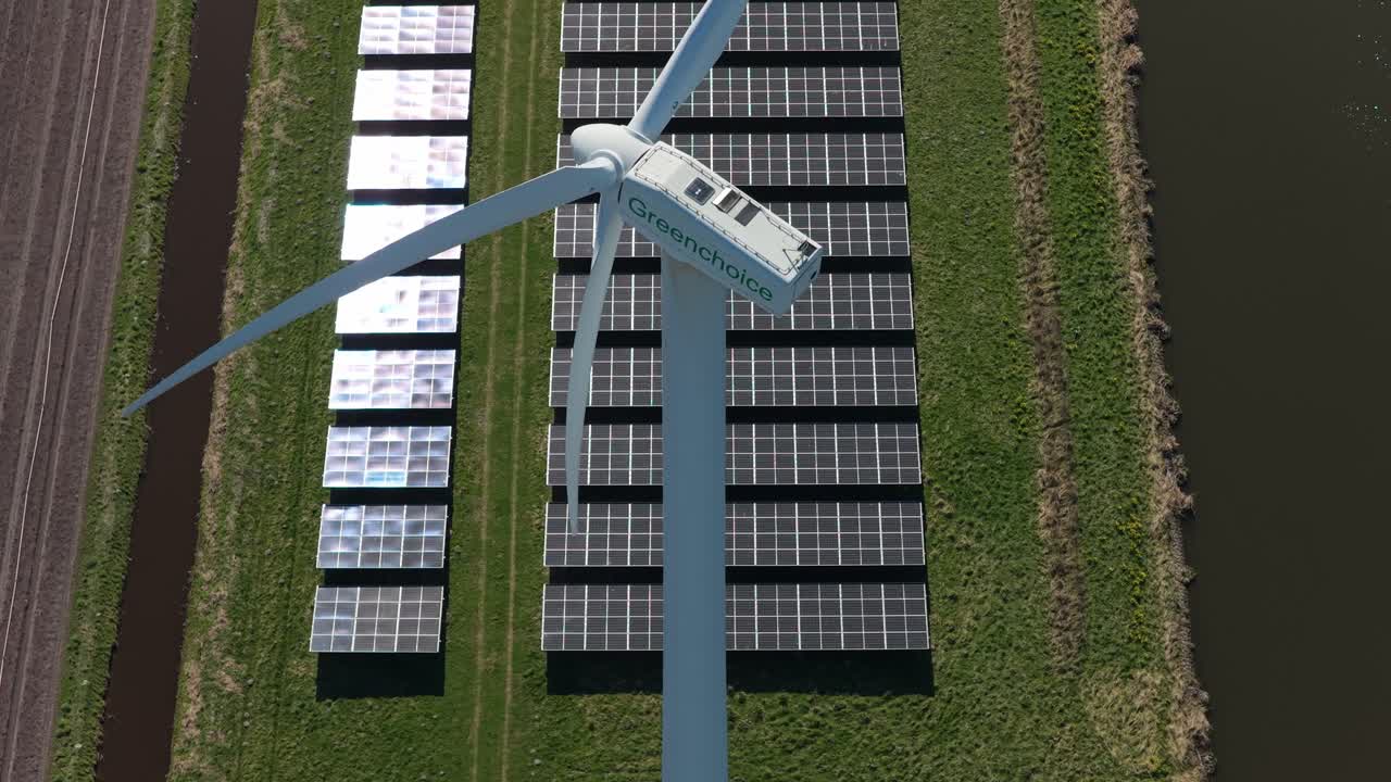 Turbina eolica e pannelli solari che generano energia sostenibile in un campo