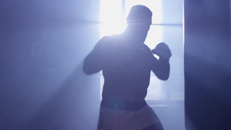 man practicing boxing in a gym