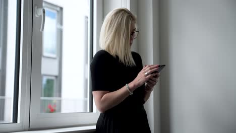 A-woman-alone-in-a-conference-room,-browsing-her-phone-while-waiting-for-others-to-arrive,-highlights-the-concept-of-patience-and-professionalism-in-business-settings