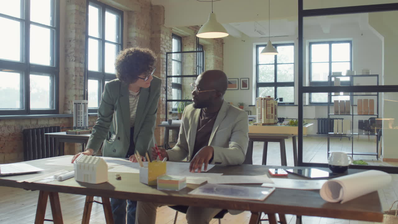 Architects Collaborating on Designs in a Modern Office
